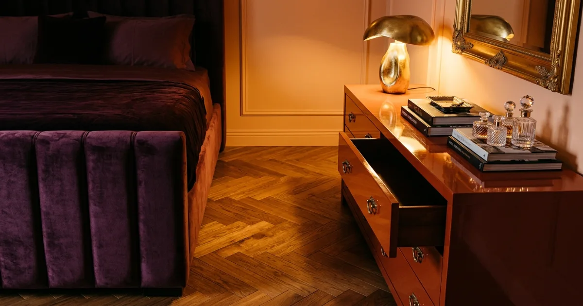 Walking space between a bed footboard and an oak dresser with a drawer open